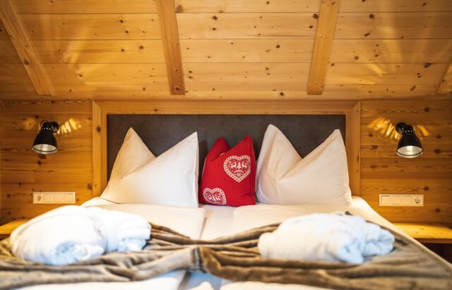 There is a double bed in a wooden chalet room
