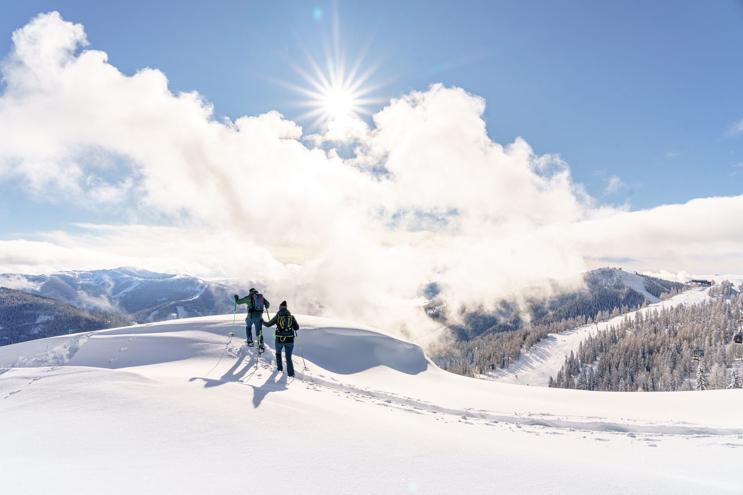 Two snowshoe hikers in the snow in the mountains.