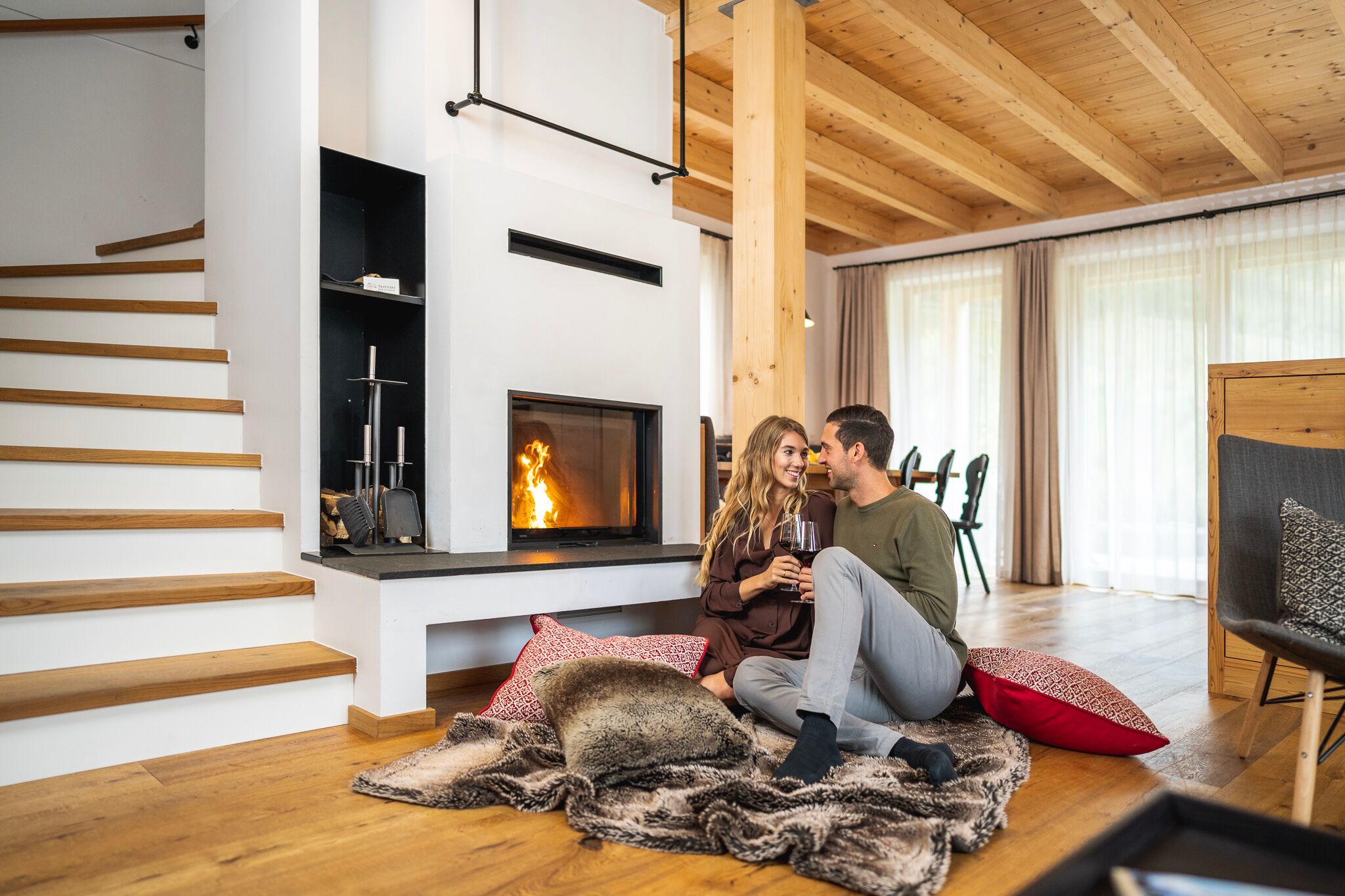 A couple has a romantic time in front of the stove of the chalet at Trattlerhof