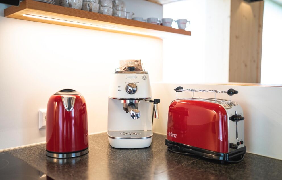 Retro-style coffee maker, toaster and kettle are in a kitchen.