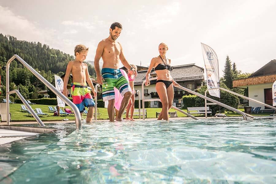 Una famiglia di quattro persone entra nella piscina delle terme di St. Kathrein in Carinzia in estate