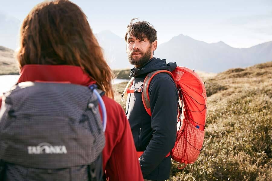 Ein Paar sind in den Bergen wandern und genießen das schöne Wetter.