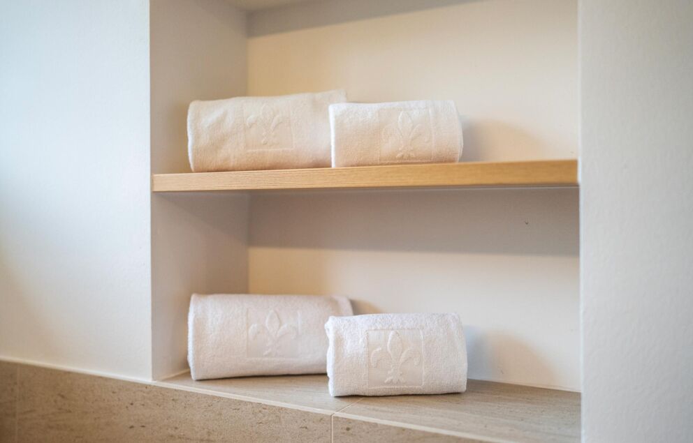 Four towels lie on the shelf