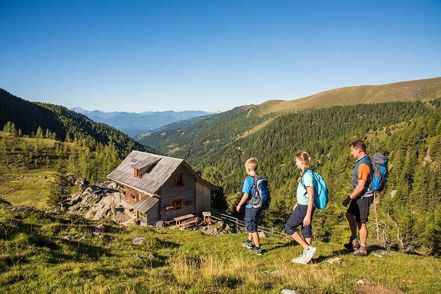 A father, mother and son go for an autumn hike on the mountains and hike to a hut