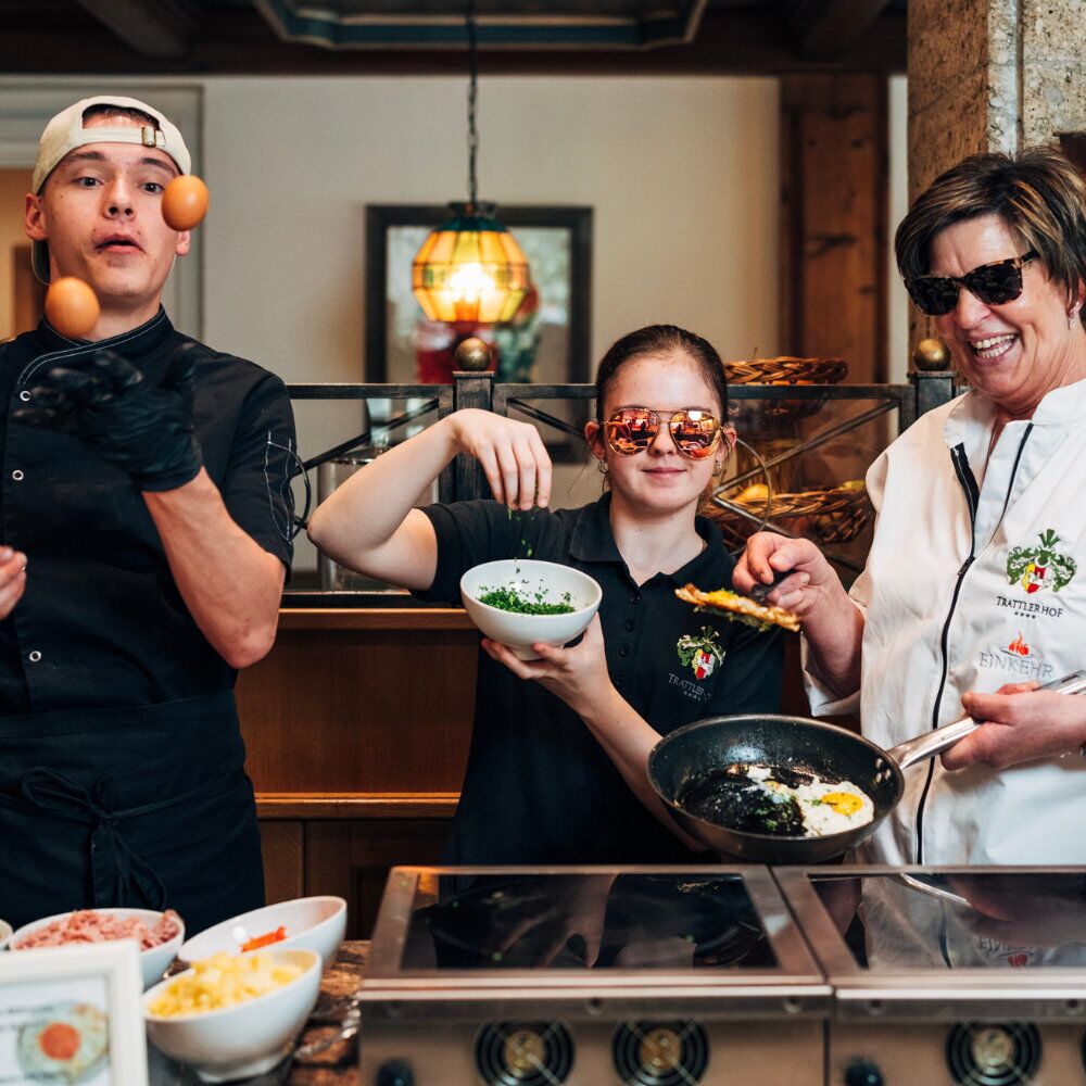 Three cooks stand in front of the cooker and present the ingredients