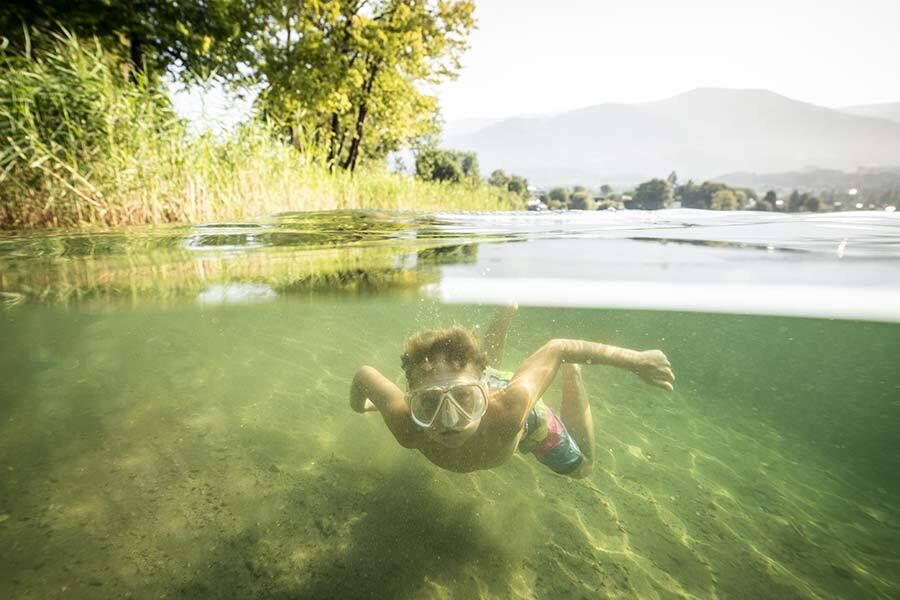 Un bambino che si immerge nel lago Millstättersee in Carinzia.