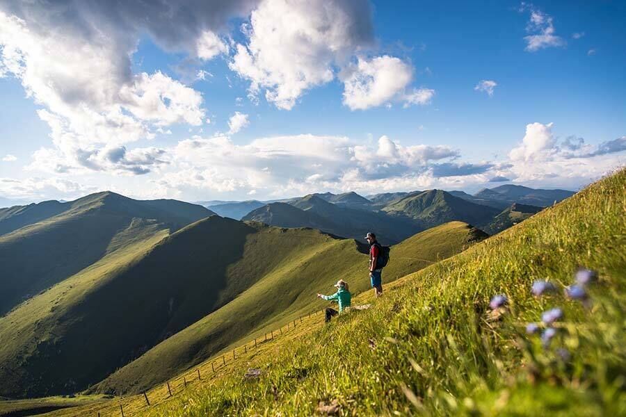 Una donna e un uomo ammirano il panorama montano in Carinzia