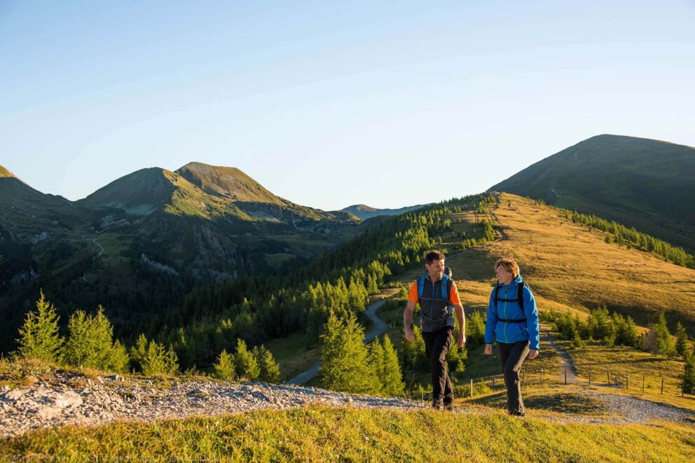 Zwei Personen die im Herbst auf den Nockbergen wandern.