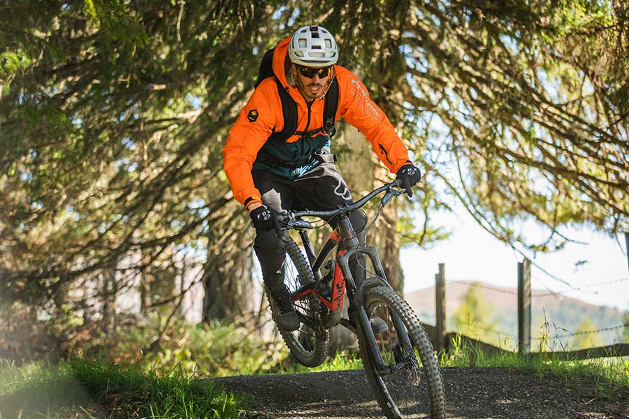 Un mountain biker percorre il Flow Country Trail nella foresta della Carinzia con il bel tempo