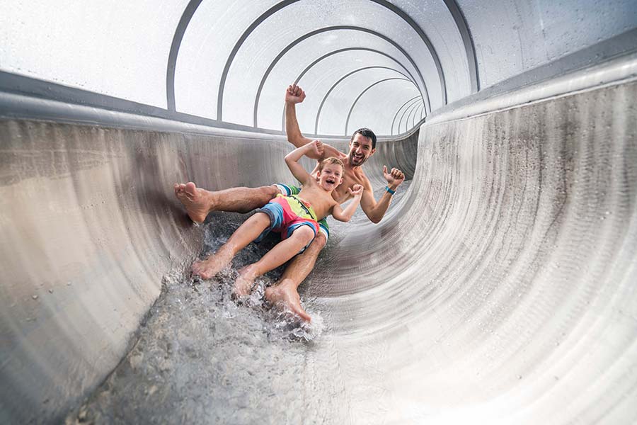 A father and his son slide in the tube slide in a Carinthian thermal spa