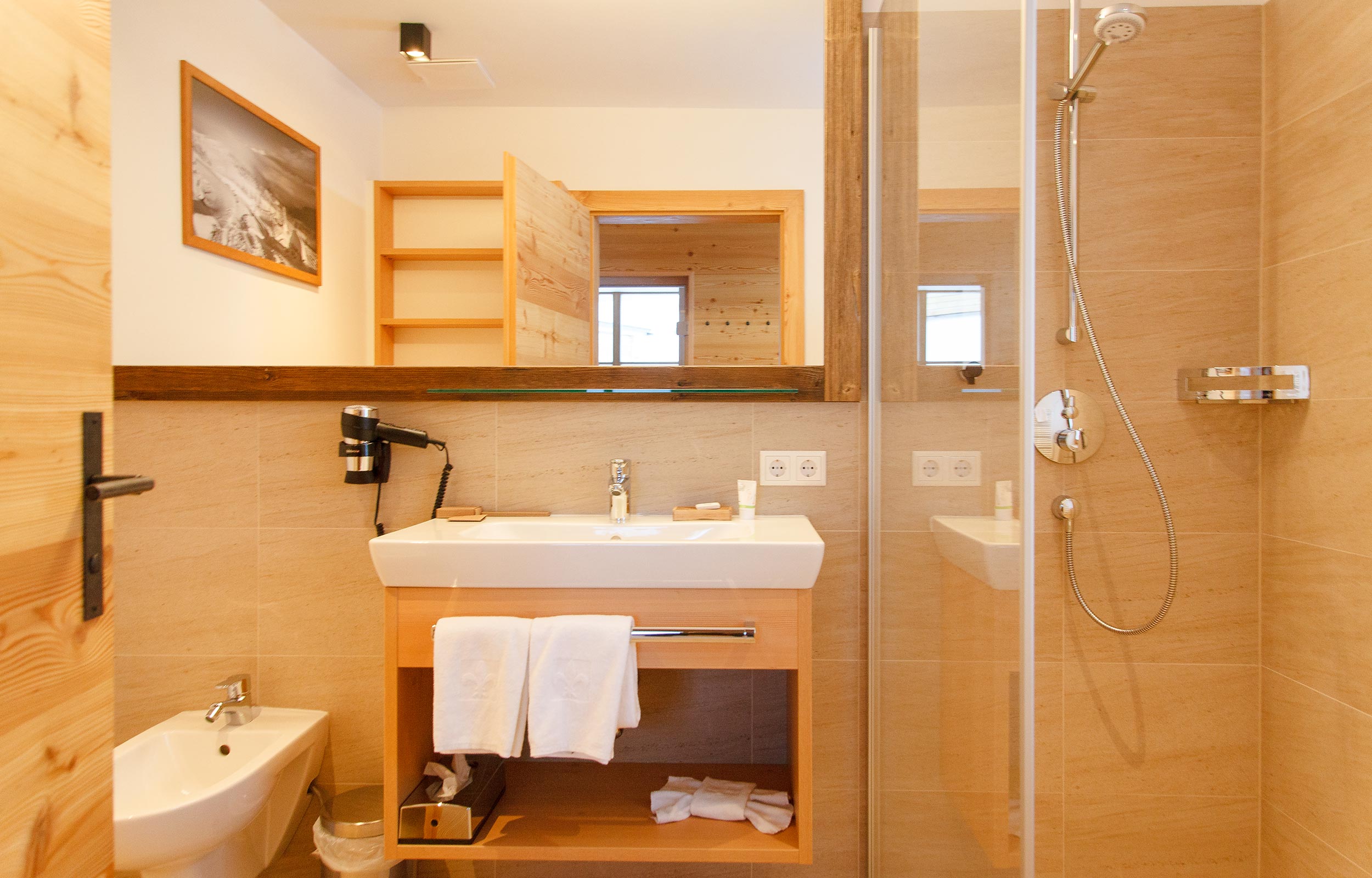 Ein vollausgestattetes Badezimmer im Chalet mit Dusche, Bidet und einem Waschbecken