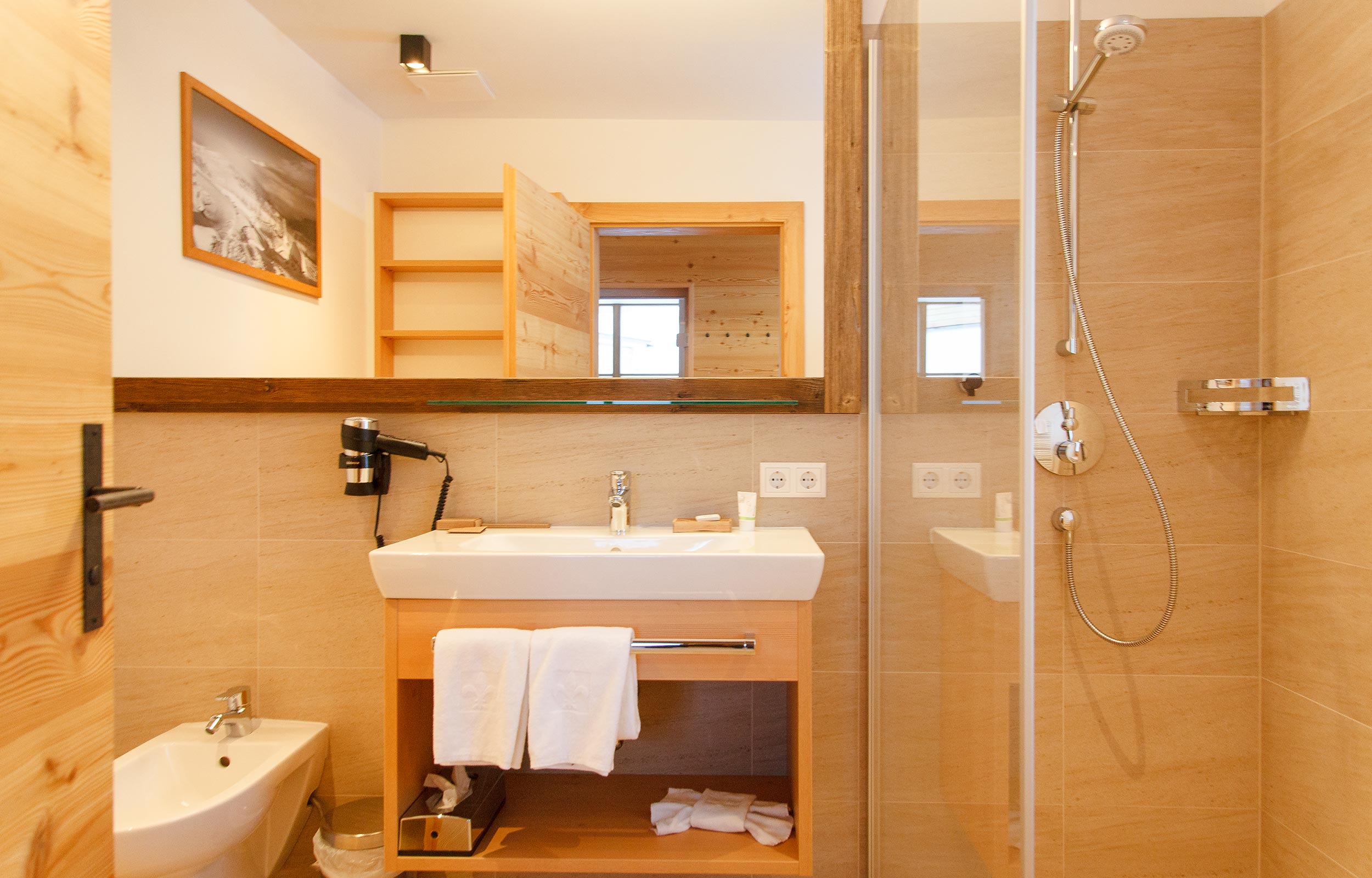 Un bagno completamente attrezzato nello chalet con doccia, bidet e lavandino