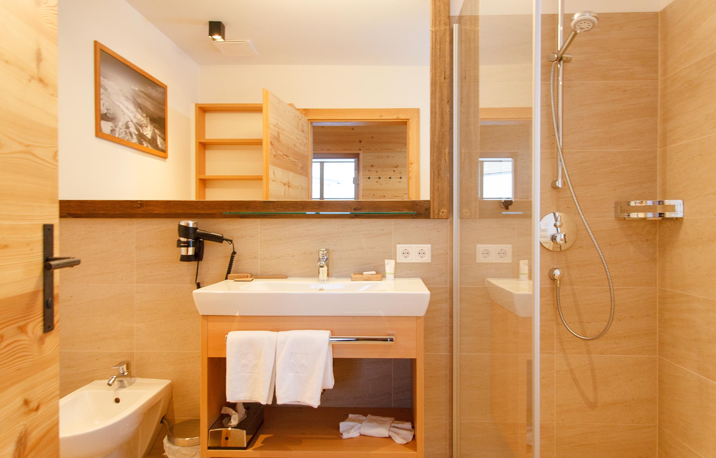 Un bagno completamente attrezzato nello chalet con doccia, bidet e lavandino